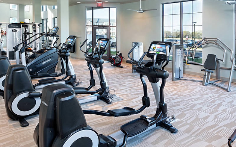 elliptical machines in fitness center with recessed lighting and ceiling fans throughout